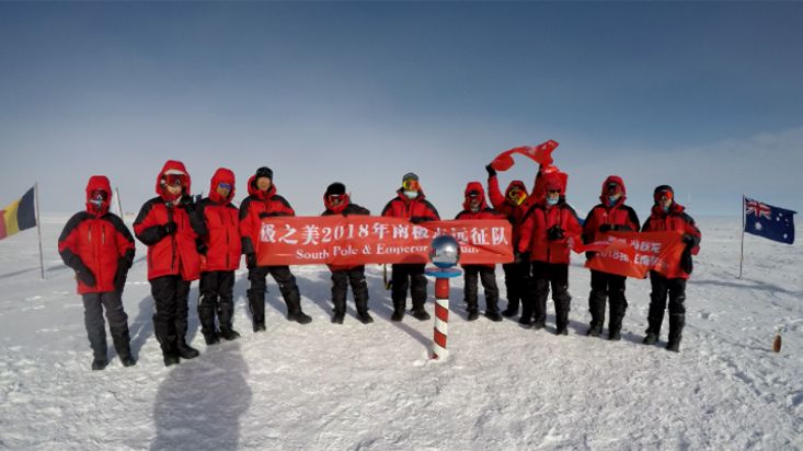 Chinese travelers jumping for joy at the ceremonial South Pole - 2018