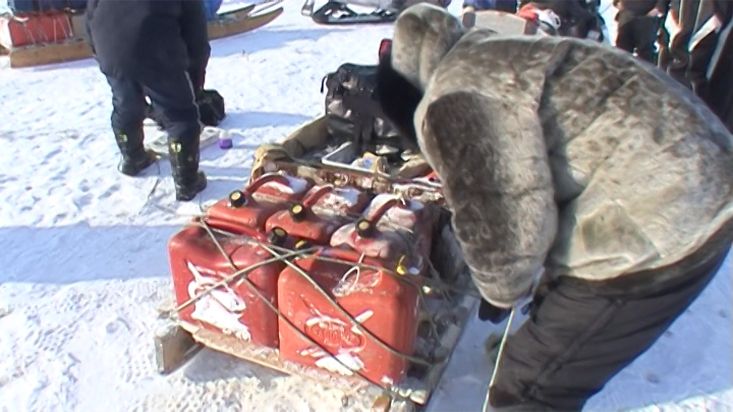 Inuit fitting the load of the snowmobiles - Penny Icecap 2009 expedition