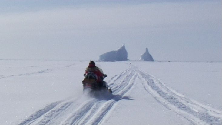 Going towards an iceberg on a snowmobile trapped in Rockstock Bay - Nanoq 2007 expedition